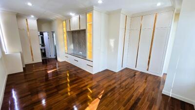 Spacious and modern living room with polished hardwood floors and built-in cabinets