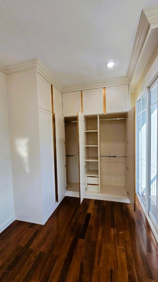 Bedroom with built-in wardrobe and hardwood flooring