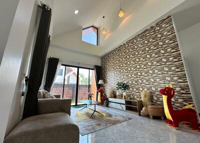 Spacious and well-lit living room with modern decor and stone accent wall