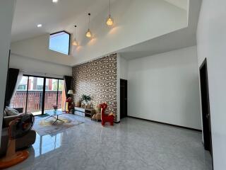 Spacious and modern living room with high ceiling and decorative stone wall