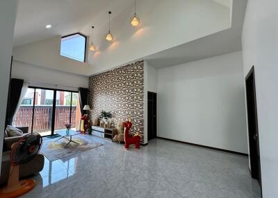 Spacious and modern living room with high ceiling and decorative stone wall