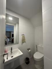 Neat bathroom with white tiles, sink, toilet, and mirrored medicine cabinet