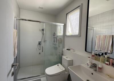 Modern spacious bathroom with glass shower enclosure and bright lighting