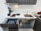 Modern compact kitchen with stainless steel fixtures and wooden cabinetry