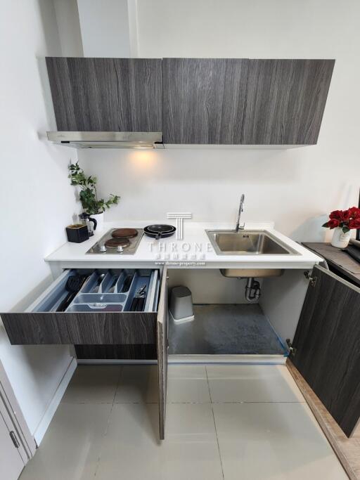 Modern compact kitchen with stainless steel fixtures and wooden cabinetry
