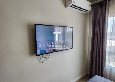 Modern bedroom with wall-mounted television and air conditioning unit