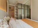 Modern bedroom with large glass-door wardrobe and stylish decor