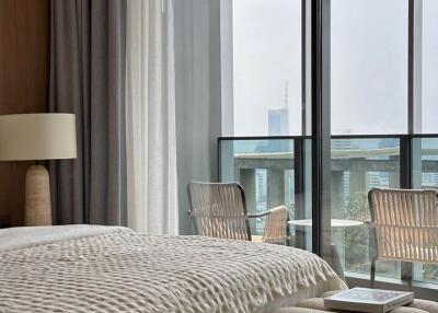 Modern bedroom with large windows overlooking the city