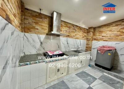 Modern kitchen with marble counters and brick walls