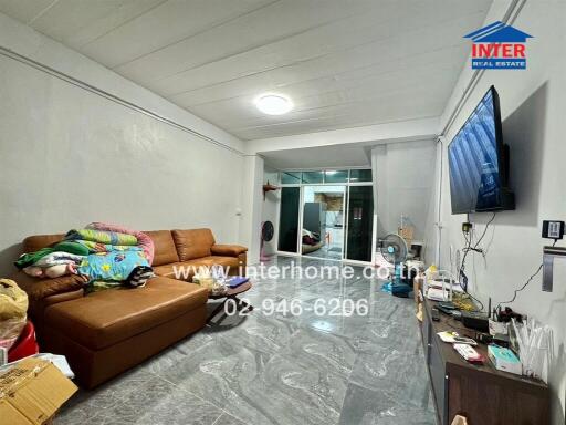 Spacious living room with sofa and large TV