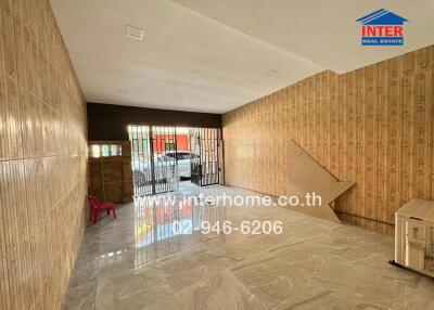 Spacious living room with ceramic tiled flooring and wooden wall paneling