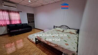 Spacious bedroom with a large bed and comfortable seating area
