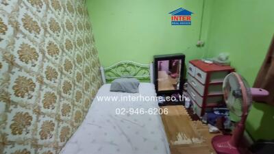 Compact bedroom with green walls and patterned curtain