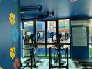 Brightly decorated indoor gym with exercise bikes and colorful walls