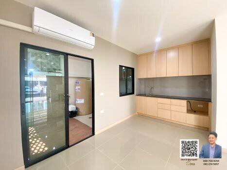 Spacious and well-lit living room with modern kitchenette