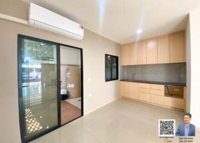 Spacious and well-lit living room with modern kitchenette