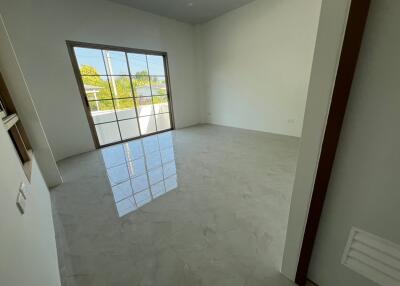 Spacious unfurnished bedroom with large window and tiled flooring