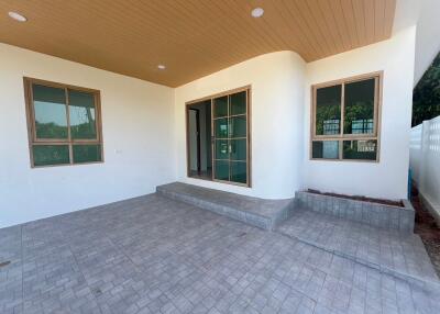 Spacious outdoor patio with tiled flooring and wood-paneled ceiling