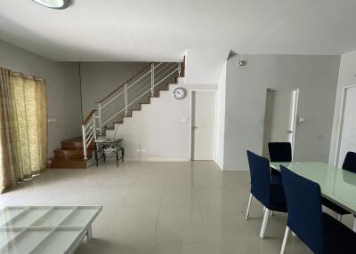 Spacious living room with stairway and dining area