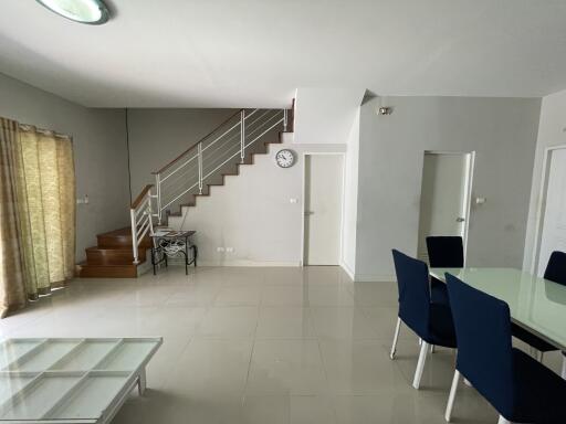 Spacious living room with stairway and dining area