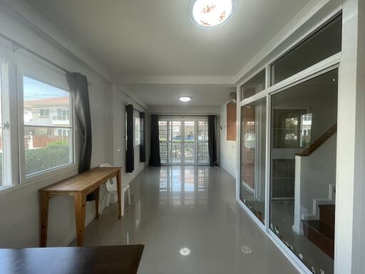 Spacious and well-lit living room with large windows and glass door