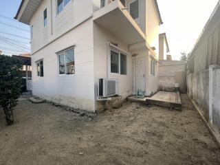 Exterior view of a two-story residential home with visible AC units and ample yard space