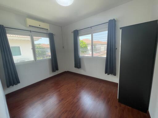 Spacious bedroom with natural lighting and hardwood floors