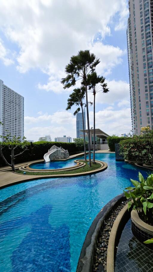 Luxurious outdoor swimming pool surrounded by high-rise buildings