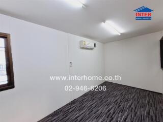 Spacious and empty room with wooden flooring and white walls