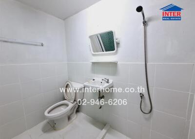 Clean and tiled bathroom with shower and toilet