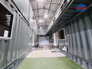 Industrial container-based corridor in a property, featuring metal walls and modern structure