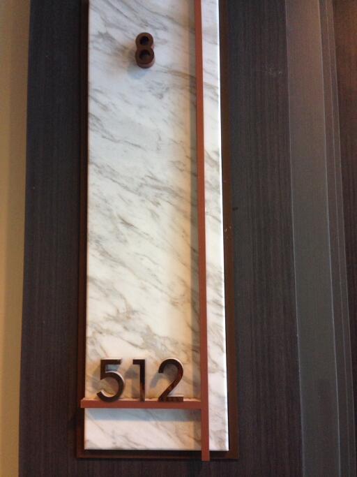 Elegant apartment door with marble finish and modern numbering