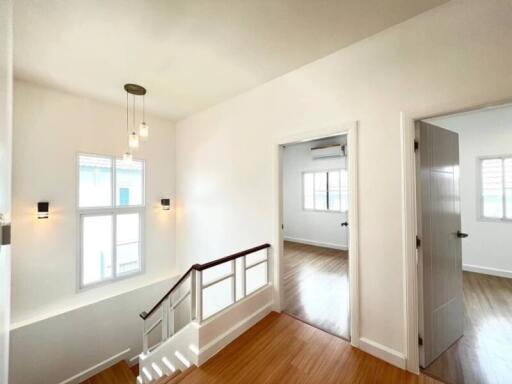 Bright and spacious landing area with wooden floors and white walls