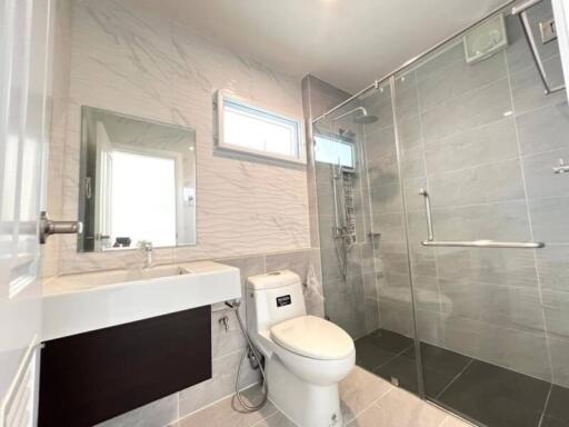 Modern bathroom with neutral colors featuring a glass shower and sleek vanity