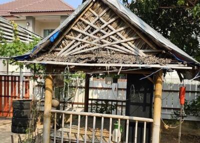 Traditional small outdoor structure with a thatched roof in a home garden