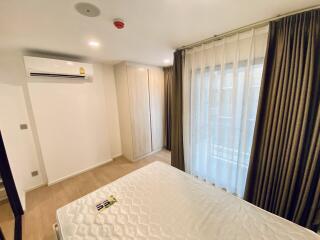 Spacious and well-lit modern bedroom with large bed and air conditioning unit