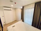 Spacious and well-lit modern bedroom with large bed and air conditioning unit