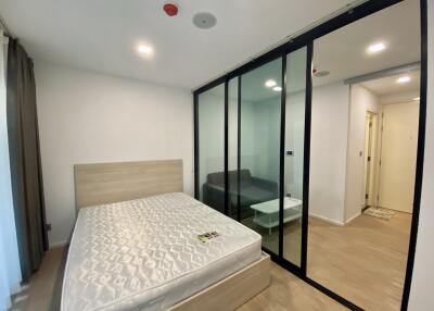 Modern bedroom with large mirrored wardrobe and adjoining living area