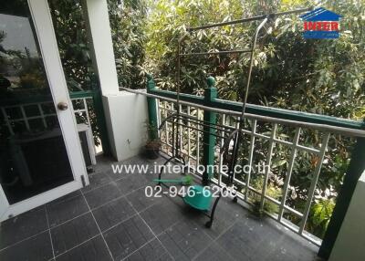 Spacious balcony with greenery view and safety railings
