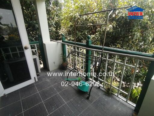 Spacious balcony with greenery view and safety railings