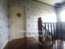 Brightly lit hallway with wooden flooring and decorative wallpaper