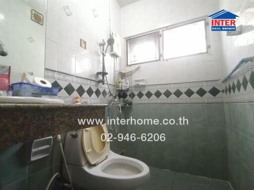Compact bathroom with grey tiles and modern amenities