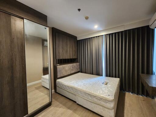 modern bedroom with large bed and mirrored wardrobe