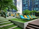 Modern apartment complex with vibrant outdoor leisure space featuring colorful lounge chairs and lush greenery