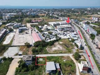 Aerial view of a residential area with marked plot for sale