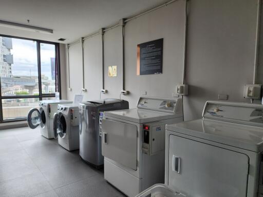 Modern laundry room in apartment building with large windows and city view