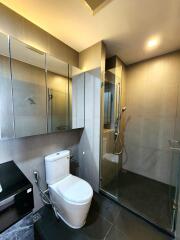 Modern bathroom with sleek design featuring a glass shower, wall-mounted sink, and toilet