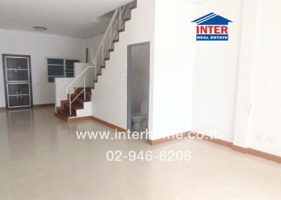 Spacious living room with staircase and tiled flooring