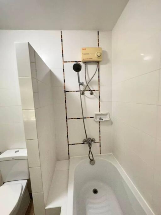 Compact bathroom with integrated shower and white tiling