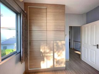 Bright bedroom with large wardrobe and scenic window view